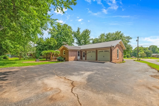 116 Skyview Dr, Columbia, TN 38401 - view of front of home with brick siding, an attached garage, asphalt driveway, and a metal roof