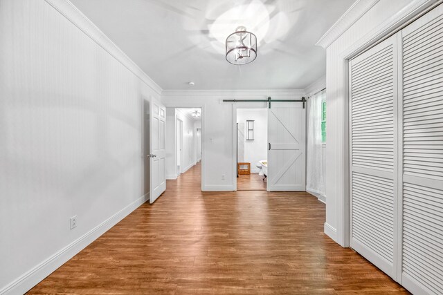 116 Skyview Dr, Columbia, TN 38401 - unfurnished bedroom featuring crown molding, a closet, wood finished floors, and a barn door