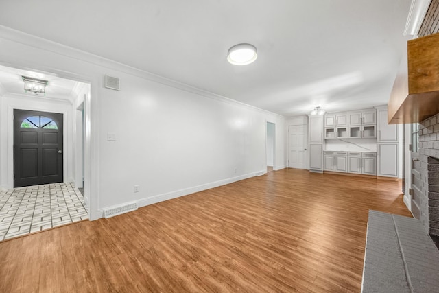 116 Skyview Dr, Columbia, TN 38401 - unfurnished living room with a brick fireplace, ornamental molding, light wood-style flooring, and a chandelier