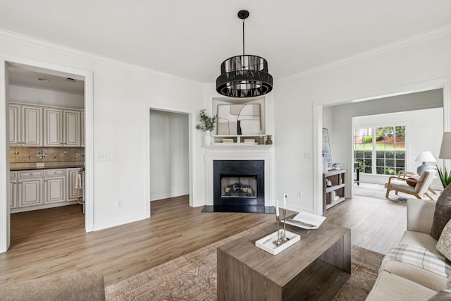 140 Ormesby Pl, Franklin, TN 37064 - living room featuring light wood-type flooring, crown molding, a fireplace, and a chandelier