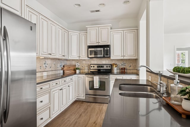 140 Ormesby Pl, Franklin, TN 37064 - kitchen featuring appliances with stainless steel finishes, dark countertops, backsplash, light wood finished floors, and recessed lighting