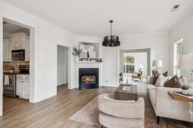 140 Ormesby Pl, Franklin, TN 37064 - living area featuring light wood-style flooring, ornamental molding, a chandelier, and a fireplace with flush hearth