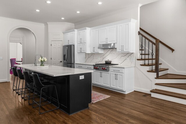 5605 Ottershaw Ct, Brentwood, TN 37027 - kitchen with stainless steel appliances, arched walkways, recessed lighting, a kitchen island with sink, and dark wood finished floors
