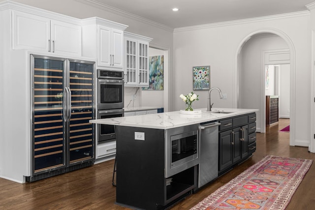5605 Ottershaw Ct, Brentwood, TN 37027 - kitchen featuring wine cooler, stainless steel appliances, white cabinetry, a center island with sink, and dark wood finished floors