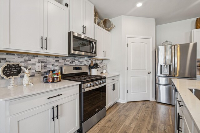 2410 Tate Farm Ln, White House, TN 37188 - kitchen with stainless steel appliances, light wood-style flooring, tasteful backsplash, white cabinets, and recessed lighting