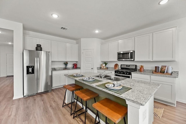 1604 Burlwood Ct, Murfreesboro, TN 37129 - kitchen with appliances with stainless steel finishes, light wood-style floors, recessed lighting, white cabinets, and a center island with sink