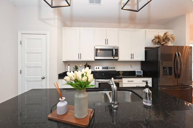 109 Santa Rosa Dr, Gallatin, TN 37066 - kitchen featuring stainless steel appliances, white cabinetry, and dark stone countertops