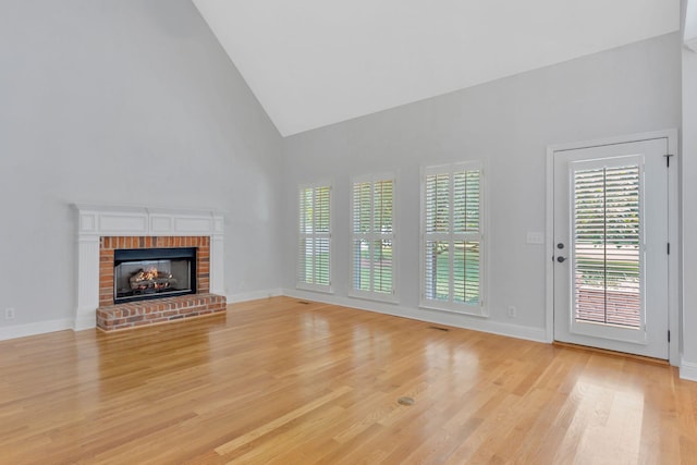 2910 Chaucer Dr, Murfreesboro, TN 37129 - unfurnished living room with high vaulted ceiling, light wood-style flooring, and a brick fireplace