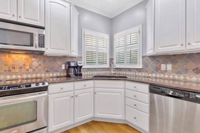 2910 Chaucer Dr, Murfreesboro, TN 37129 - kitchen featuring appliances with stainless steel finishes, dark countertops, white cabinetry, ornamental molding, and backsplash