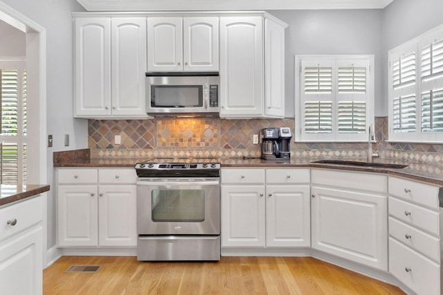 2910 Chaucer Dr, Murfreesboro, TN 37129 - kitchen with appliances with stainless steel finishes, light wood finished floors, tasteful backsplash, and white cabinetry