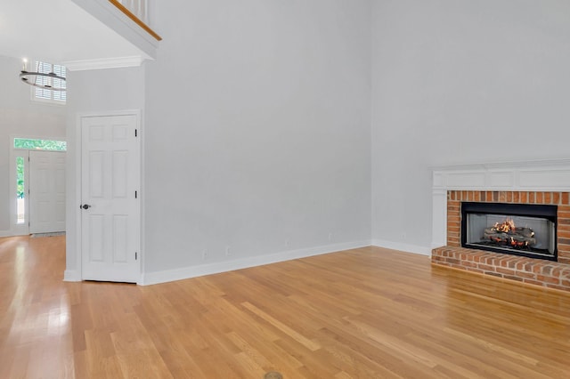 2910 Chaucer Dr, Murfreesboro, TN 37129 - unfurnished living room featuring a high ceiling, light wood-style floors, and a brick fireplace
