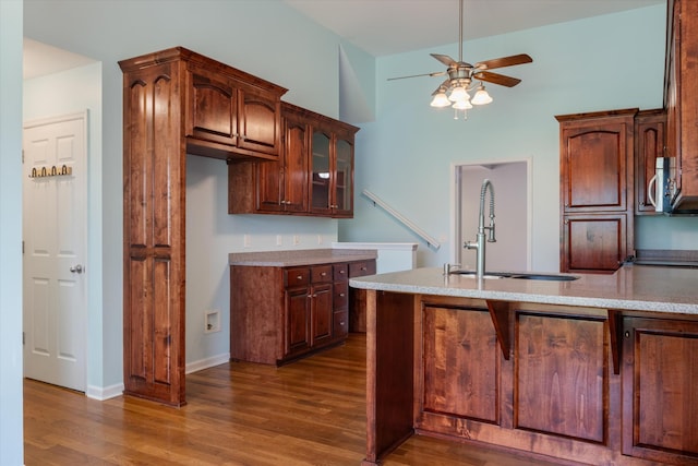 717 Pleasant View Dr, Columbia, TN 38401 - kitchen with a ceiling fan, dark wood-style flooring, glass insert cabinets, a peninsula, and light stone counters