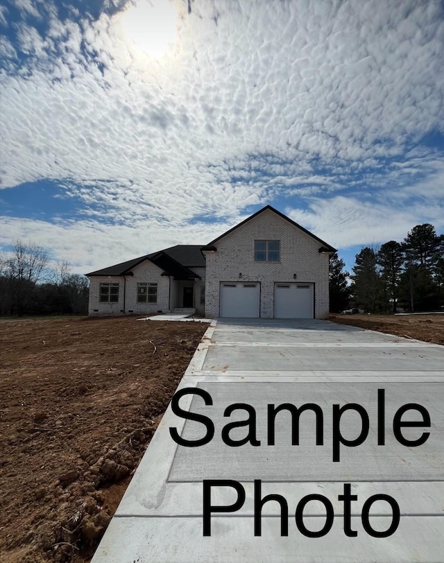 390 Young Ln, Pleasant View, TN 37146 - view of front of home featuring an attached garage, concrete driveway, and brick siding
