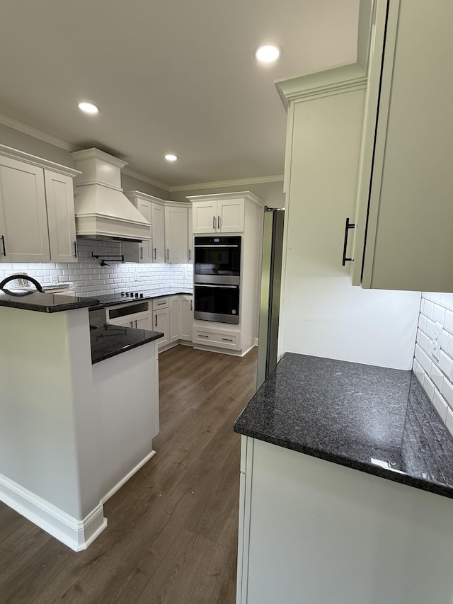 711 Johnson St, Clarksville, TN 37043 - kitchen with custom range hood, stainless steel appliances, white cabinets, tasteful backsplash, and dark wood-type flooring