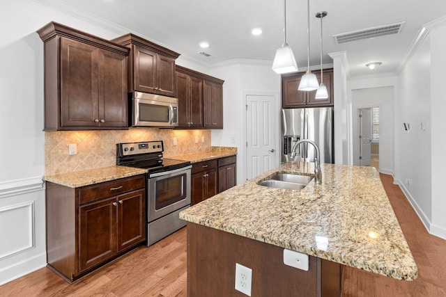 526 Sydenham Dr, Franklin, TN 37064 - kitchen with stainless steel appliances, light wood finished floors, dark brown cabinets, tasteful backsplash, and light stone counters