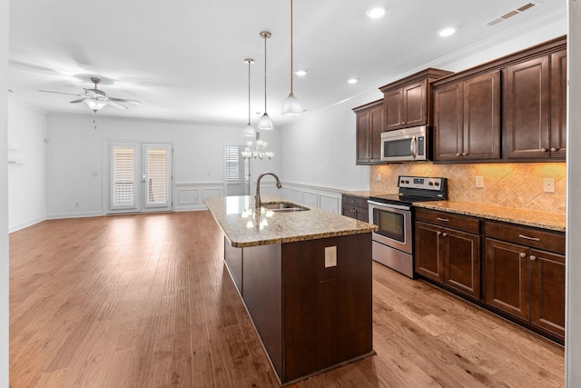 526 Sydenham Dr, Franklin, TN 37064 - kitchen with stainless steel appliances, a center island with sink, dark brown cabinets, light stone counters, and ceiling fan
