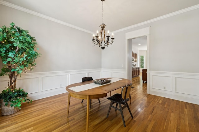 4019 Fremantle Cir, Spring Hill, TN 37174 - dining room with a chandelier, wood finished floors, crown molding, wainscoting, and a decorative wall