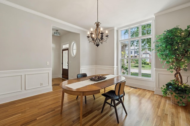 4019 Fremantle Cir, Spring Hill, TN 37174 - dining area featuring a chandelier, ornamental molding, light wood-style flooring, a wainscoted wall, and a decorative wall