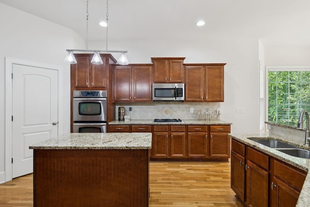 4019 Fremantle Cir, Spring Hill, TN 37174 - kitchen featuring stainless steel appliances, light wood-type flooring, decorative backsplash, light stone countertops, and hanging light fixtures