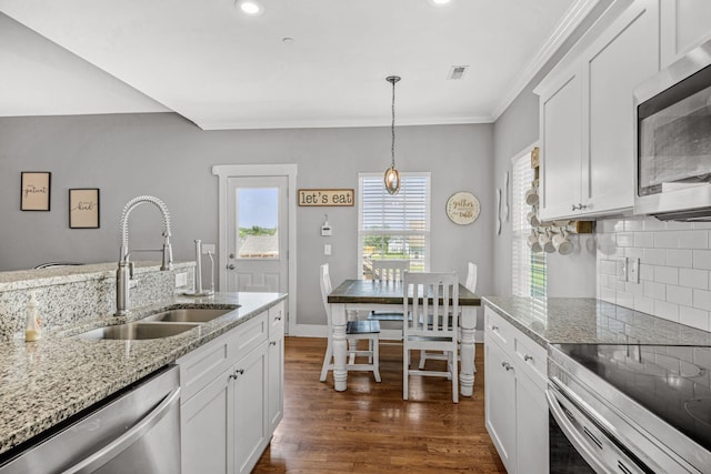 1021 Tulip Dr, Ashland City, TN 37015 - kitchen with appliances with stainless steel finishes, white cabinetry, dark wood-style flooring, ornamental molding, and tasteful backsplash