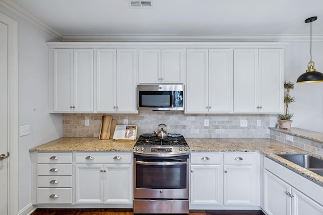 9020 Wenlock Ln, Franklin, TN 37064 - kitchen with stainless steel appliances, white cabinets, backsplash, light stone counters, and ornamental molding
