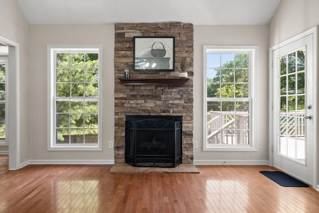 4328 Monticello Trce, Adams, TN 37010 - unfurnished living room featuring hardwood / wood-style floors, healthy amount of natural light, and a stone fireplace