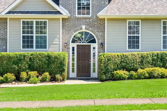 4328 Monticello Trce, Adams, TN 37010 - doorway to property with a shingled roof, a lawn, and brick siding