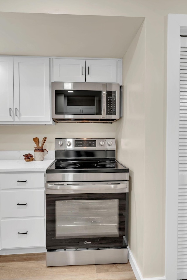1221 Katie Ave Unit A, Nashville, TN 37207 - kitchen with appliances with stainless steel finishes, white cabinets, light countertops, and light wood-style flooring
