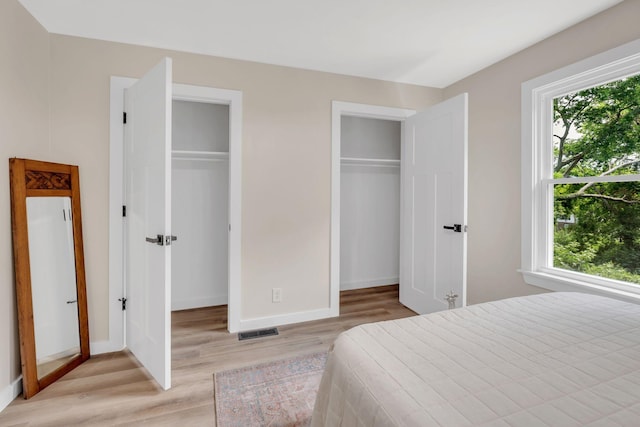 1221 Katie Ave Unit A, Nashville, TN 37207 - bedroom with multiple windows, light wood-type flooring, and two closets