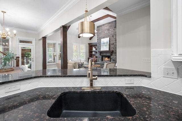 1313 Jewell Ave, Franklin, TN 37064 - kitchen with a fireplace, dark stone countertops, crown molding, and hanging light fixtures