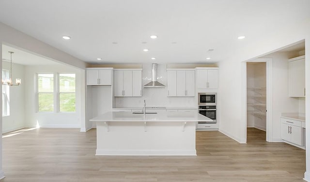 2901 Windstone Trl, Columbia, TN 38401 - kitchen with stainless steel oven, built in microwave, wall chimney exhaust hood, light countertops, and white cabinetry