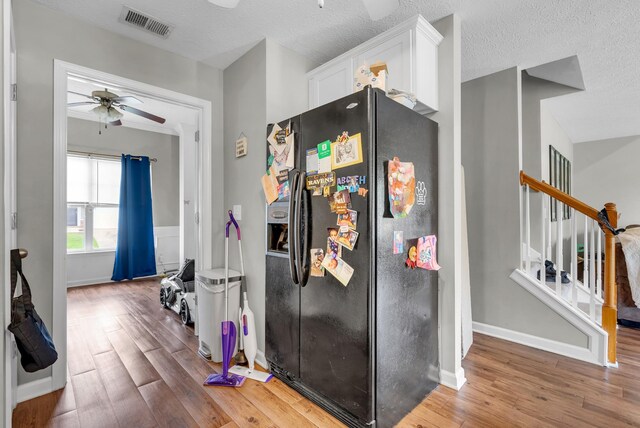1515 Bridgecrest Dr Unit 408, Antioch, TN 37013 - kitchen featuring black fridge with ice dispenser, ceiling fan, wood finished floors, white cabinets, and a textured ceiling