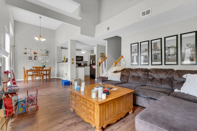 1515 Bridgecrest Dr Unit 408, Antioch, TN 37013 - living room featuring high vaulted ceiling, wood finished floors, a ceiling fan, stairs, and a chandelier