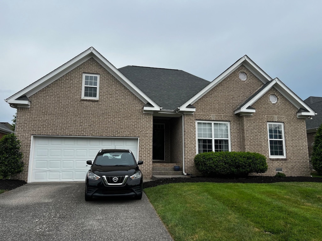 1025 Aenon Cir, Spring Hill, TN 37174 - traditional home with brick siding, asphalt driveway, a front yard, and roof with shingles