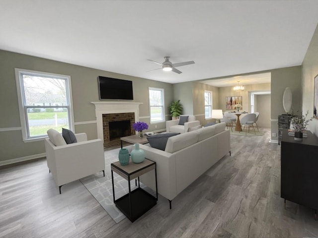 621 Buck Ln, Murfreesboro, TN 37129 - living room featuring light wood-style flooring, a fireplace, a ceiling fan, and a chandelier
