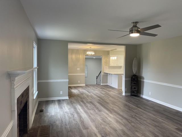 621 Buck Ln, Murfreesboro, TN 37129 - unfurnished living room with ceiling fan, dark wood-style floors, a brick fireplace, and a chandelier