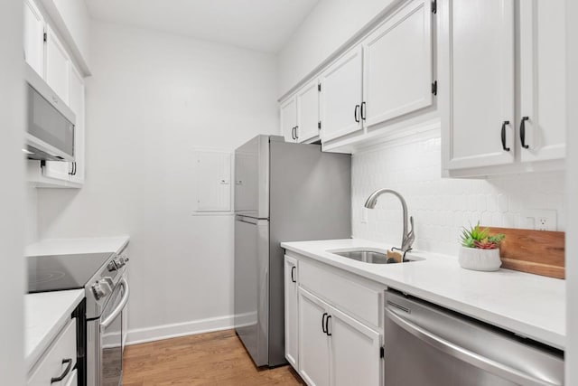 416 Sloan Rd, Nashville, TN 37209 - kitchen featuring appliances with stainless steel finishes, white cabinetry, backsplash, light countertops, and light wood-type flooring