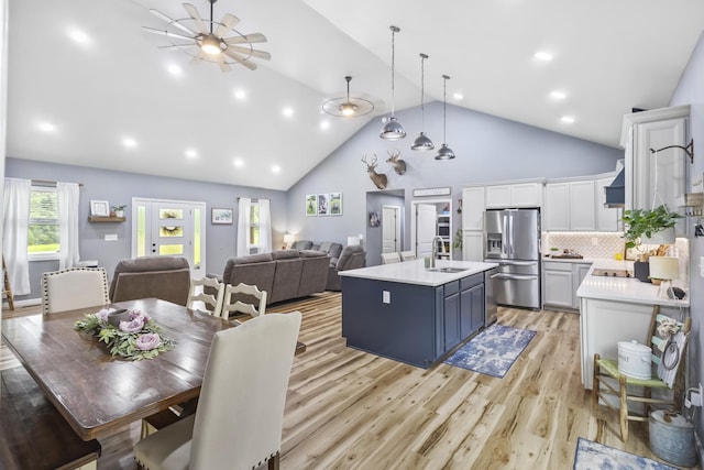 1567 Oak Knob Rd, Lafayette, TN 37083 - kitchen featuring stainless steel fridge, light countertops, an island with sink, white cabinetry, and light wood-style flooring