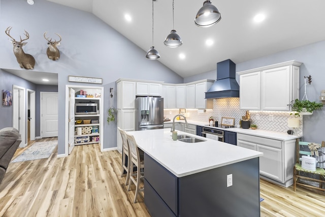 1567 Oak Knob Rd, Lafayette, TN 37083 - kitchen with stainless steel appliances, wall chimney exhaust hood, white cabinets, high vaulted ceiling, and a kitchen bar