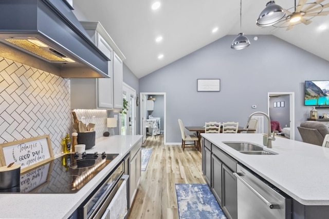 1567 Oak Knob Rd, Lafayette, TN 37083 - kitchen featuring stainless steel appliances, wall chimney exhaust hood, vaulted ceiling, light countertops, and light wood-type flooring