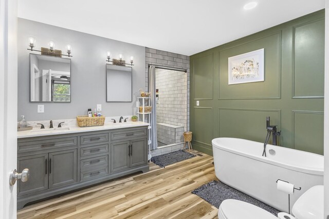 1567 Oak Knob Rd, Lafayette, TN 37083 - full bathroom featuring double vanity, a freestanding tub, a stall shower, and wood finished floors