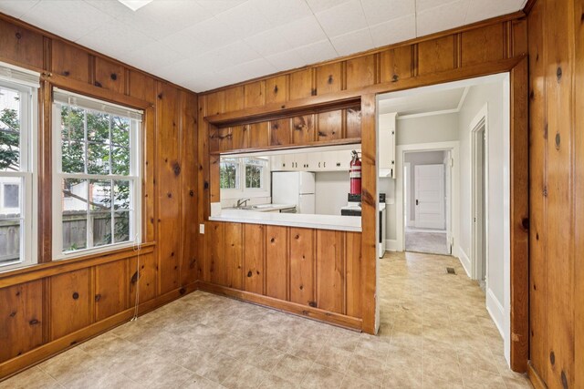 1221 W Commerce St W, Lewisburg, TN 37091 - kitchen with freestanding refrigerator, wooden walls, light countertops, brown cabinets, and a peninsula