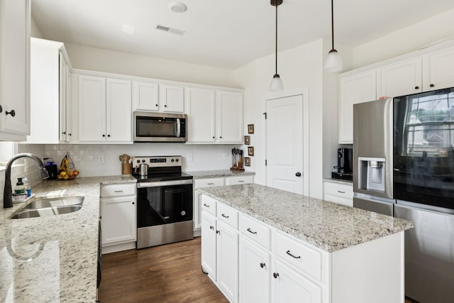 6007 Cavalry Ct, Spring Hill, TN 37174 - kitchen featuring stainless steel appliances, a kitchen island, white cabinetry, backsplash, and pendant lighting
