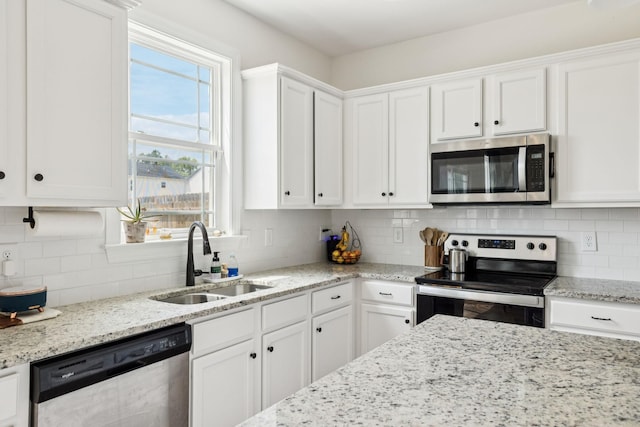 6007 Cavalry Ct, Spring Hill, TN 37174 - kitchen featuring appliances with stainless steel finishes, white cabinets, tasteful backsplash, and light stone countertops