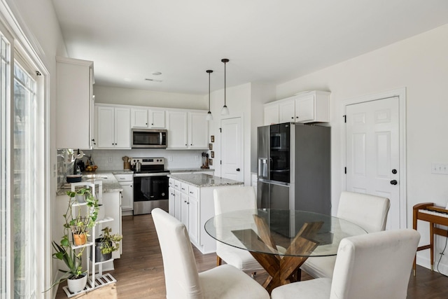 6007 Cavalry Ct, Spring Hill, TN 37174 - kitchen with appliances with stainless steel finishes, a kitchen island, white cabinets, and dark wood-type flooring
