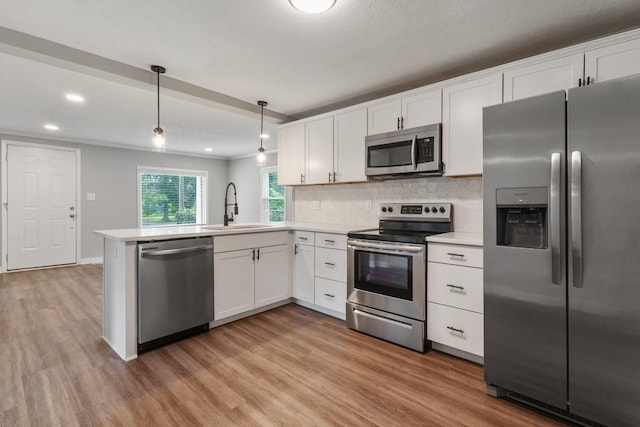 706 Poplar Ave, Murfreesboro, TN 37130 - kitchen with appliances with stainless steel finishes, light countertops, light wood-style floors, white cabinetry, and recessed lighting