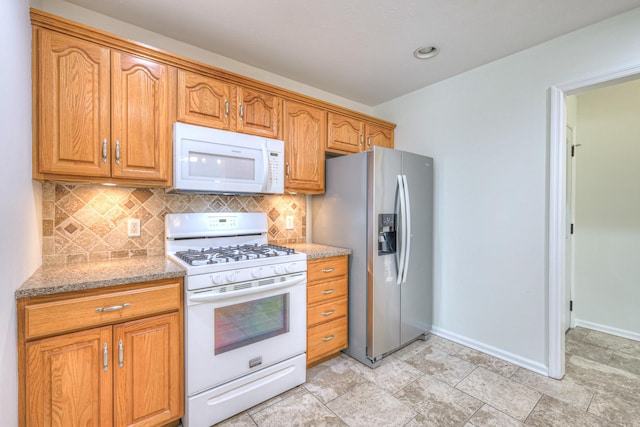 2902 Crenshaw Ct, Spring Hill, TN 37174 - kitchen with white appliances, tasteful backsplash, light stone countertops, and brown cabinets
