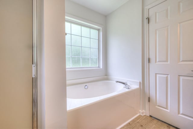 2902 Crenshaw Ct, Spring Hill, TN 37174 - bathroom featuring a garden tub and wood finished floors
