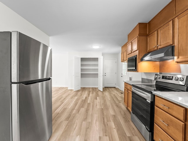 206 Elk Acre Dr, Estill Springs, TN 37330 - kitchen with stainless steel appliances, under cabinet range hood, light wood-type flooring, and brown cabinetry