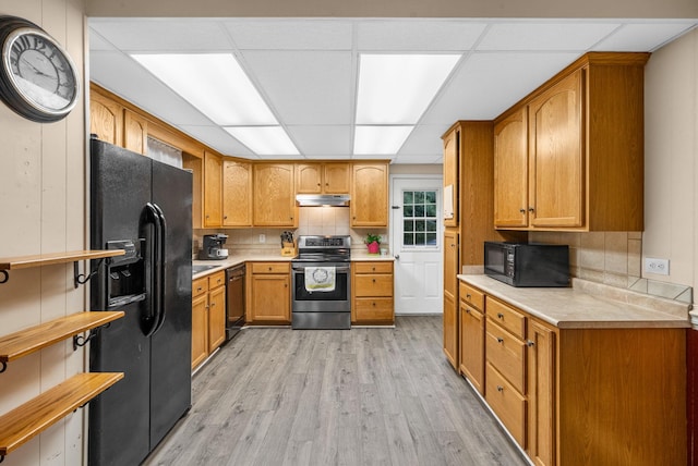 305 Barry Dr, Clarksville, TN 37040 - kitchen with black appliances, under cabinet range hood, light wood-type flooring, and light countertops